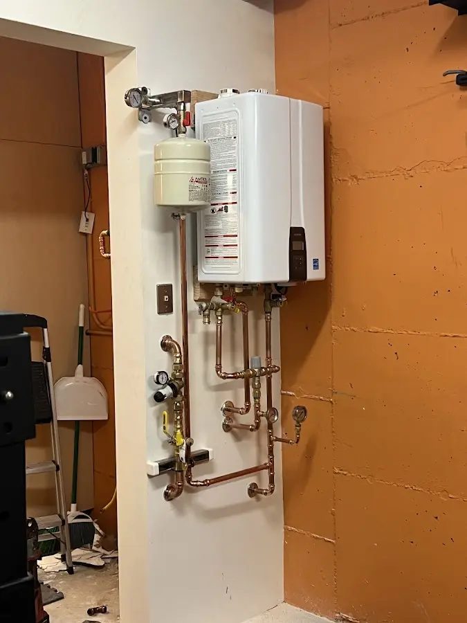 Plumbing technician inspecting water heater connections in Dock Junction